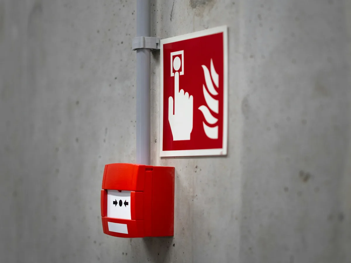 A fire alarm pull station on a commercial building wall
