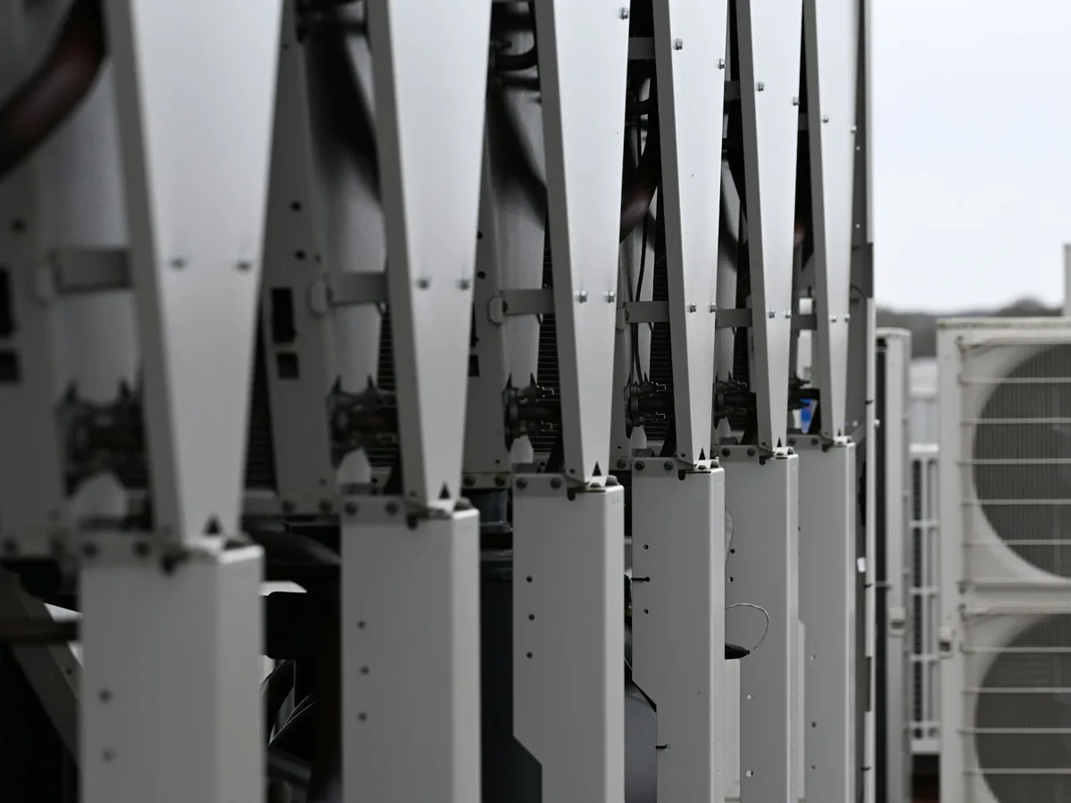 A row of rooftop HVAC units on a commercial building
