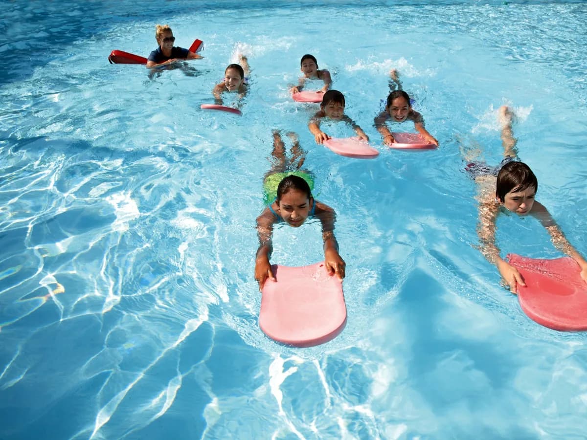 Children in a swimming lesson at an indoor pool